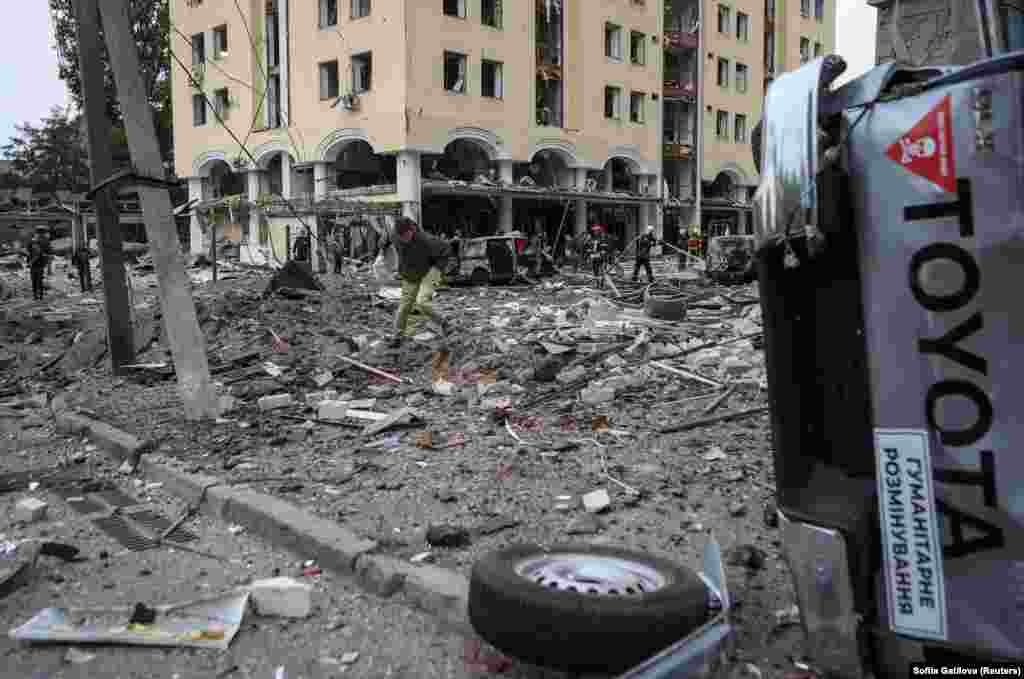 A man walks across debris at the site of the strike.