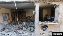 Ljudi u uništenoj kući nakon izraelskog napada u Rafahu u južnom Pojasu Gaze, 8. februara 2024.