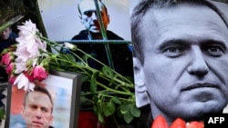 Flowers are seen placed around portraits of late Russian opposition leader Aleksei Navalny at a makeshift memorial in front of the former Russian consulate in Frankfurt, Germany, on February 23.