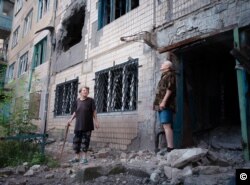 Avdiyivka residents Lila and Lyona look up at the sky as a shell whistles past overhead.