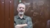 Igor Girkin sits behind a glass wall of an enclosure for defendants before a court hearing in Moscow on July 21.