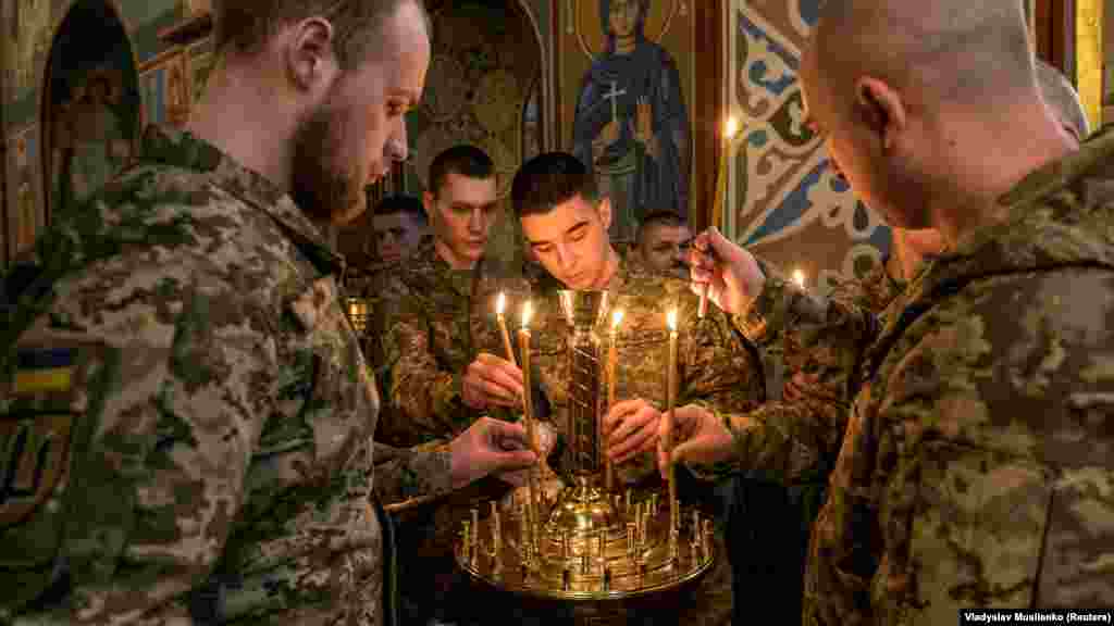 Gyertyákat helyeznek el ukrán katonák a húsvéti kalácsot megáldó istentiszteletet követően a kijevi Szent Mihály-székesegyházban április 12-én