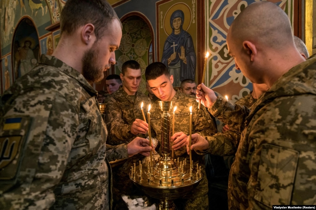 Ushtarë ukrainas ndezin qirinj pas një shërbimi për forcat e armatosura ukrainase në Katedralen e Shën Michaelit në Kiev.