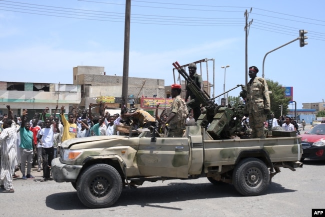 Sudanese greet soldiers loyal to army chief Abdel Fattah al-Burhan in the Red Sea city of Port Sudan on April 16.