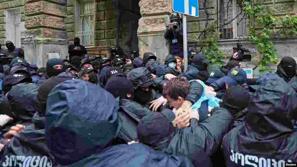 A tbiliszi rendőrség könnygázzal, vízágyúval és a beszámolók szerint gumilövedékkel is lőtt a georgiai parlament előtt összegyűlt tüntetőkre, valamint néhány tüntetőt megvertek.&nbsp;A törvény miatt a parlamentben is pattanásig feszült a hangulat, a képviselők több ízben összeverekedtek