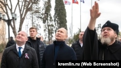 Владимир Путин и митрополит Тихон (крайний справа) во время открытия художественной школы в аннексированном Крыму, 18 марта 2023 года