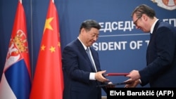 Chinese leader Xi Jinping (left) and Serbian President Aleksandar Vucic exchange agreements during a signing ceremony on May 8 in Belgrade.