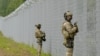 Latvian border guard officers patrol along the fence along the Latvia-Belarus border near Robeznieki, Latvia, on August 8.