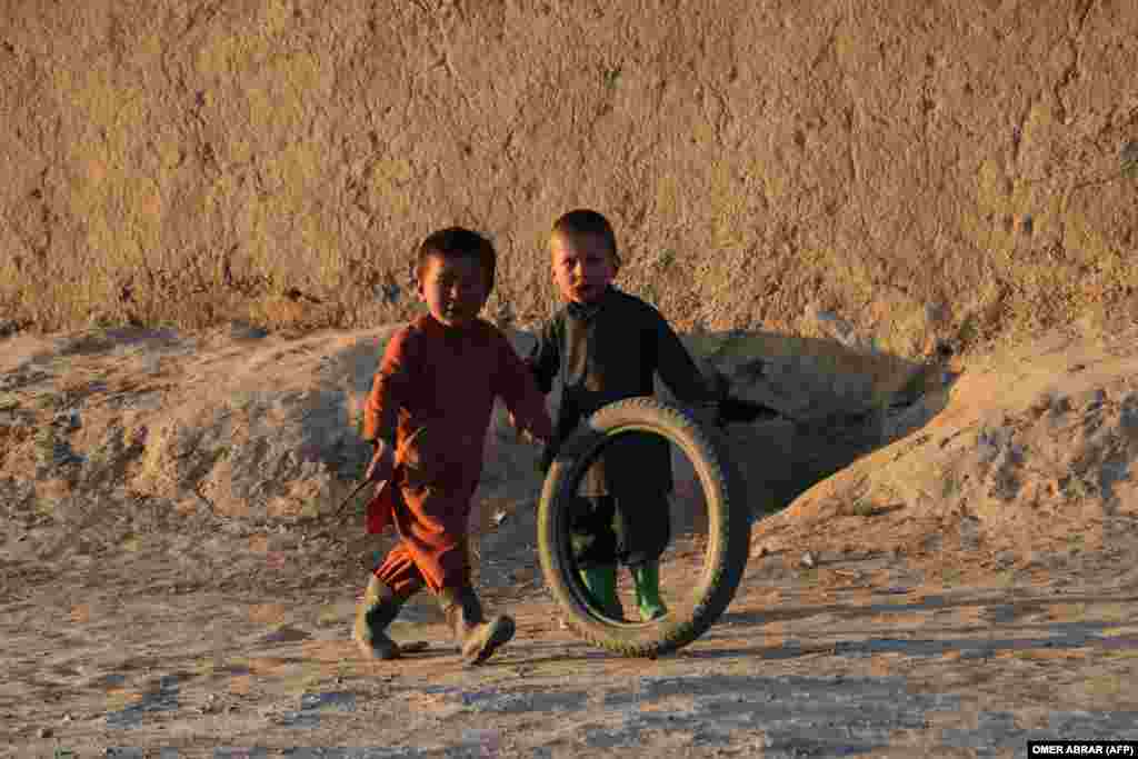 Afghan children play with a tire along a street in the Argo district of Badakhshan Province.