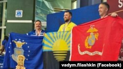 Артем Кайдан (у центрі) із прапором Донеччини