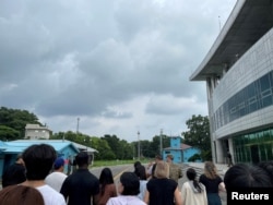 Рядовой США Трэвис Т. Кинг (в чёрной рубашке и чёрной кепке) виден на этом снимке, сделанном во время тура по жёстко контролируемой совместной зоне безопасности (JSA) на границе между двумя Кореями, в деревне перемирия Пханмунджом, Юг. Корея, 18 июля 2023 года