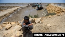 A boy waits to be evacuated to government relief camps before the expected arrival of a cyclone in the Sujawal district of Sindh Province on June 12.