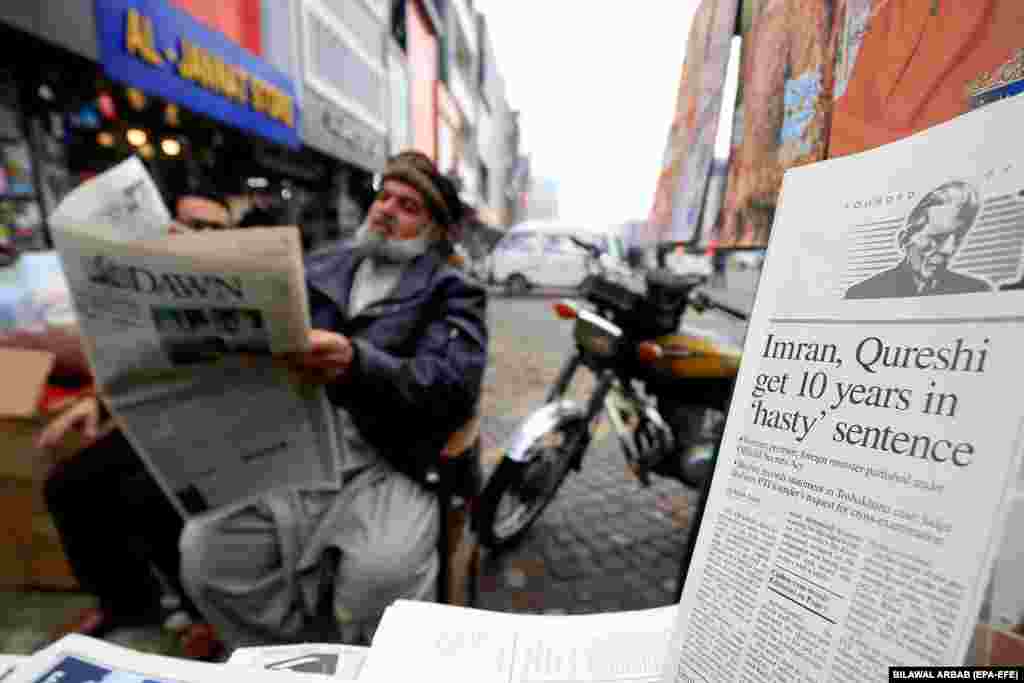 A man reads a newspaper reporting on the prison sentence for former Prime Minister Imran Khan in Peshawar, Pakistan.