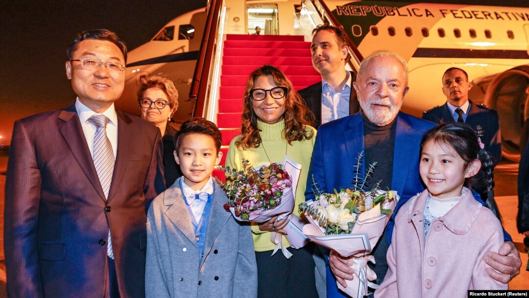 Brazilian President Luiz Inacio Lula da Silva holds flowers next to First Lady Rosangela "Janja" da Silva and China's vice minister of foreign affairs, Xie Feng in Shanghai on April 13.