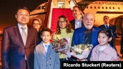 Brazilian President Luiz Inacio Lula da Silva holds flowers next to First Lady Rosangela "Janja" da Silva and China's vice minister of foreign affairs, Xie Feng in Shanghai on April 13.