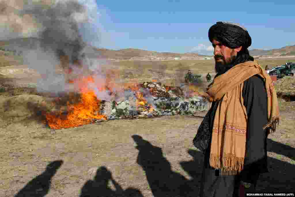 Taliban security personnel stand guard while authorities burn drugs and alcoholic drinks on the outskirts of Ghazni Province, Afghanistan.