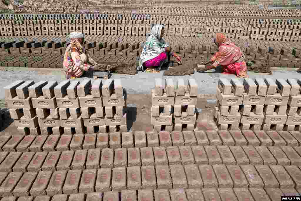 Women bake clay bricks at a kiln on the outskirts of Lahore, Pakistan.