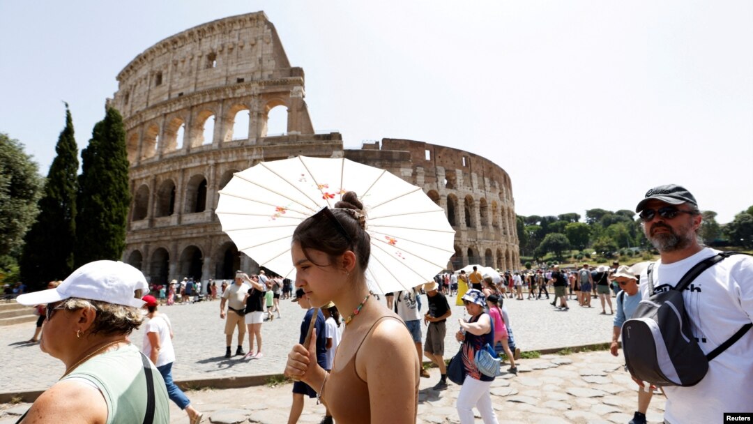 Turiștii afectați de caniculă merg pe lângă Colosseum în timpul valului de căldură care afectează Italia, în timp ce se așteaptă ca temperaturile să crească și mai mult în următoarele zile, Roma, Italia, 17 iulie 2023.