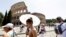Turiștii afectați de caniculă merg pe lângă Colosseum în timpul valului de căldură care afectează Italia, în timp ce se așteaptă ca temperaturile să crească și mai mult în următoarele zile, Roma, Italia, 17 iulie 2023.