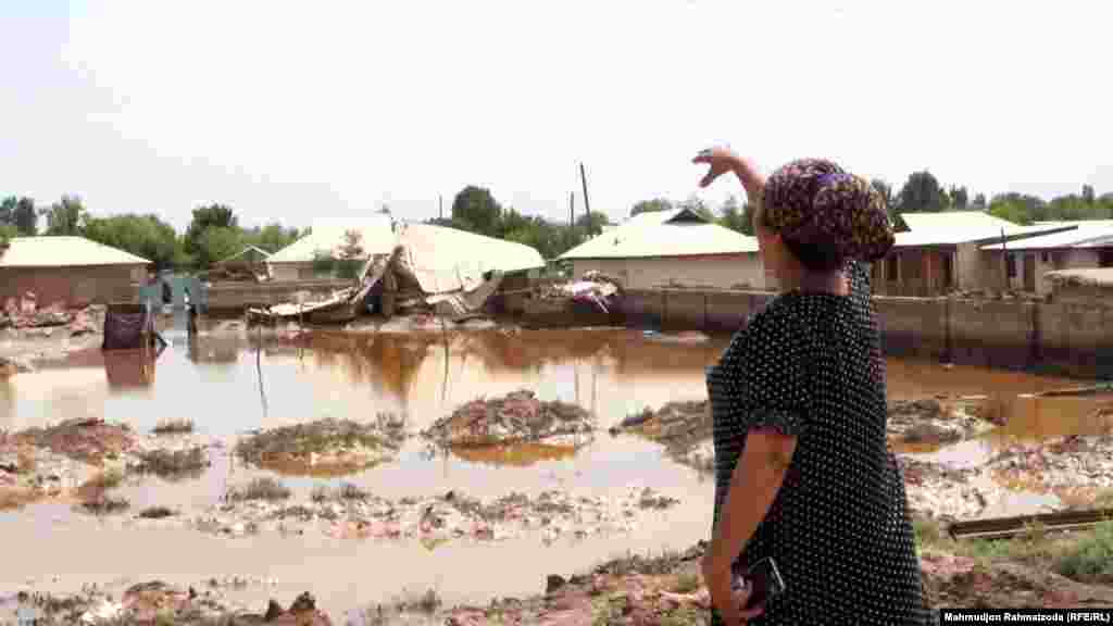 A woman gestures toward flooded homes in the village of Surkhob, in northern Tajikistan, on May 27.&nbsp; &nbsp;