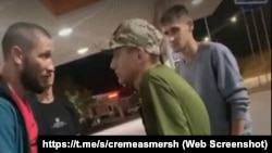 Крымчанин Длявер Салимов (слева) и сотрудник заправки в кепке со знаком Z. Скриншот с видео, опубликованного Telegram-каналом «Крымский СМЕРШ», август 2023 года