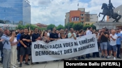 Novinari na protestu u Prištini sa transparentom na kojem piše: "Demokratija umire u mraku", 31. juli 2023.