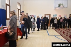 People line up to vote at a polling station in Baku on February 7.