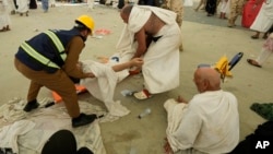 Bolničari nose muslimanskog hodočasnika na medicinski pregled nakon što je pao zbog toplotnog udara u Mini, u blizini svetog grada Meke, Saudijska Arabija, u nedjelju, 16. juna 2024.