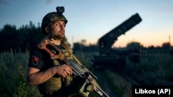 Український військовий на тлі трофейної системи «Сонцепьок» на лінії фронту поблизу Кремінної, 7 липня 2023 року