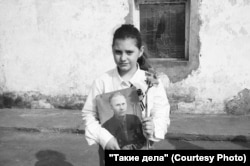 Një vajzë e re mban një foto. Më 9 maj, rusët marshojnë me fotografi të të afërmve që dhanë jetën ose kontribuuan në Luftën e Dytë Botërore.