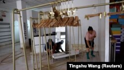 Čišćenje prodavnice nakon poplave izazvane jakom kišom u pokrajini Hebei, Kina, 7. avgust 2023.