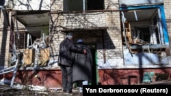 Люди заходять у будинок, пошкоджений ракетним ударом у Краматорську 14 березня 2023 року