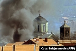 O biserică ortodoxă sârbă din orașul nordic Mitrovica arde în martie 2004.