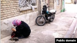 عکس آرشیوی از یک فرد معتاد در حال استعمال مواد مخدر در خیابانی در ایران
