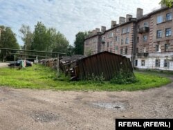 Тухлени жилищни блокове за офицери и порутени бараки, които очевидно някога са служили за гаражи.