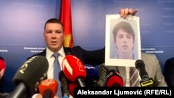 Ministar unutrašnjih poslova Filip Adžić drži fotografiju jednog od osumnjičenih Veljka Markovića za umiješanost u kupanje tunela do depoa Višeg suda u Podgorici.