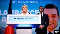 Марин Ле Пен, символ французских ультраправых, выступает в ходе кампании перед выборами в Европарламент. Справа от неё (и на плакате на заднем плане) — преемник Ле Пен на посту лидера партии «Национальное объединение» Жордан Барделла