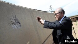 Armenia - A foreign diplomat takes a photo of a bullet hole at a construction site in Yeraskh, June 15, 2023.