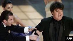  Антонио Бандерас и положителната му другарка и колежка Пенелопе Крус дърпат Педро Алмодовар от сцената, откакто е приказвал прекомерно дълго след премията 