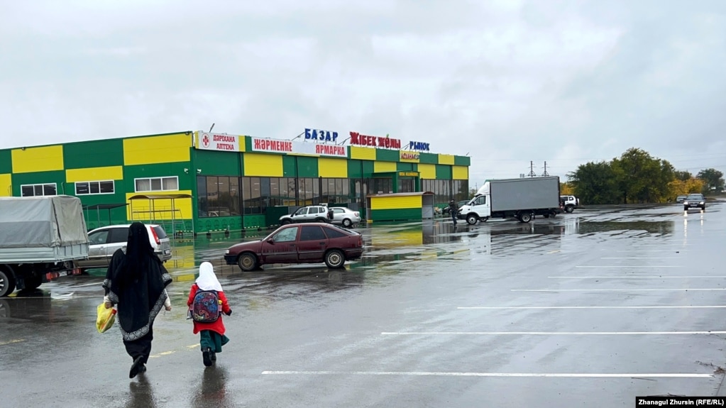 Женщина в никабе идет с ребенком к рынку в Актобе. 6 октября 2023 года