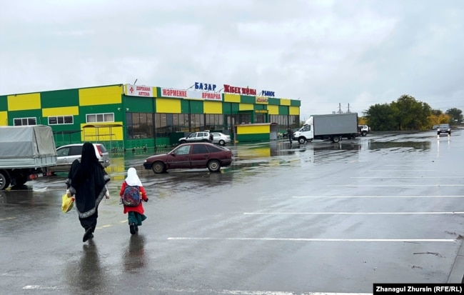 Көшеде кетіп бара жатқан ниқаб киген әйел мен орамал тартқан оқушы қыз. Ақтөбе қаласы Жібек жолы ықшамауданы, 6 қазан, 2023 жыл.