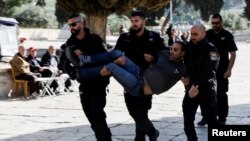 Policia izraelite duke e tërhequr me forcë një palestinez. 5 prill 2023.