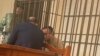 Ukrainian citizen Volodymyr Kadaria in a defendant's cage in a Bishkek courtroom on March 1.
