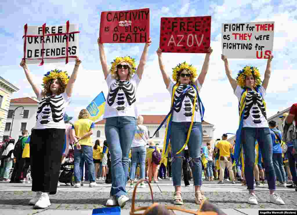 Дівчата у віночках кольорів прапору України тримають плакати на підтримку бійців бригади &laquo;Азов&raquo;, які зараз перебувають у полоні в Росії, перед початком футбольного матчу Україна-Румунія на Євро-2024 у Мюнхені, Німеччина, 17 червня 2024 року