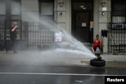 Njujorčani pokušavaju da se rashlade tokom toplotnog talasa pored otvorenog hidranta, 17. juli 2023.