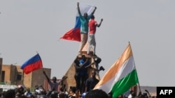 Protesters wave Nigerien and Russian flags as they gather during a rally in support of Niger's junta in Niamey on July 30.