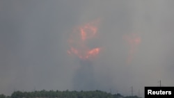 Дым и пламя поднимаются от взрыва во время пожара на военном полигоне в Кировском районе, Крым, 19 июля 2023 года