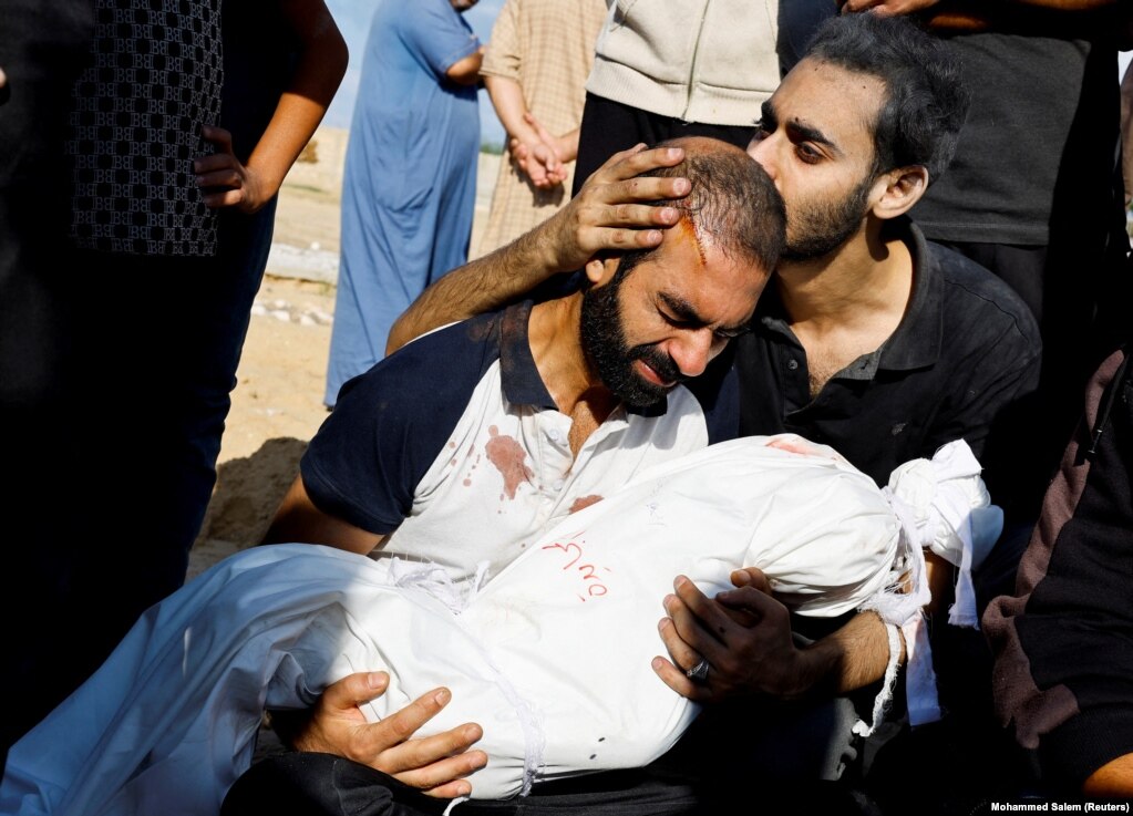 Babai i Alma Al Majayda, tre vjeçe, e vrarë në sulmet izraelite, përqafon trupin e saj gjatë funeralit, në Khan Younis, 19 tetor 2023.