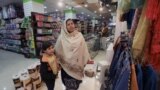 په پېښور کې یوه ښځه په مارکېټ کې په دوکانونو ګرځي - پخوانی انځور. 