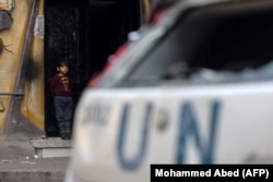 Палестинский мальчик возле своего дома рядом с поврежденным автомобилем ООН в Рафахе на юге сектора Газа. 4 марта 2024 года